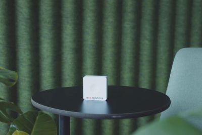 eco2solutions | ein eco2state Sensor zur Nachrüstung steht auf rundem Tisch vor grünem Hintergrund